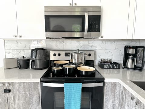 Fully stocked kitchen with pots, pans and appliances.