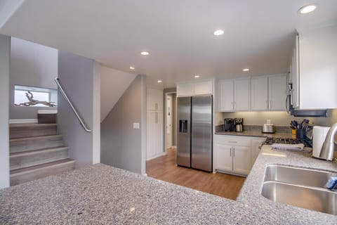 Second Floor: kitchen with stainless steel appliances, dining area, and balcony views.