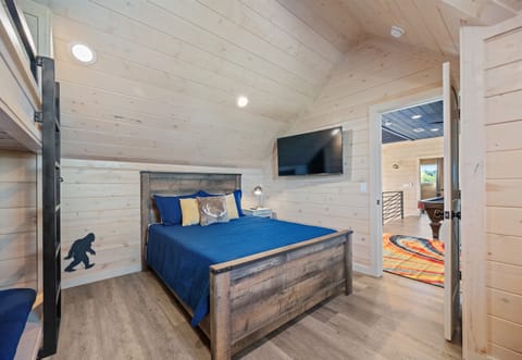 Bedroom 4 with queen bed and TV, cozy space for guests.