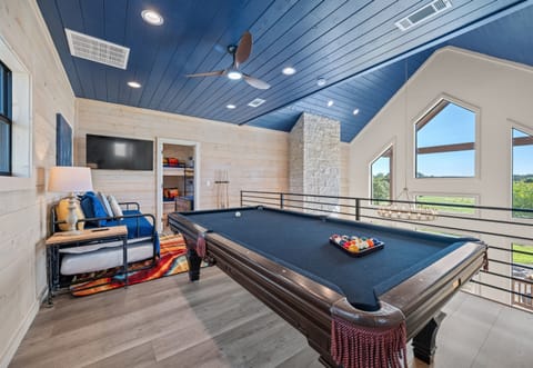 Game room with pool table, cozy seating, and TV. Great for relaxing and hanging out with friends or family.