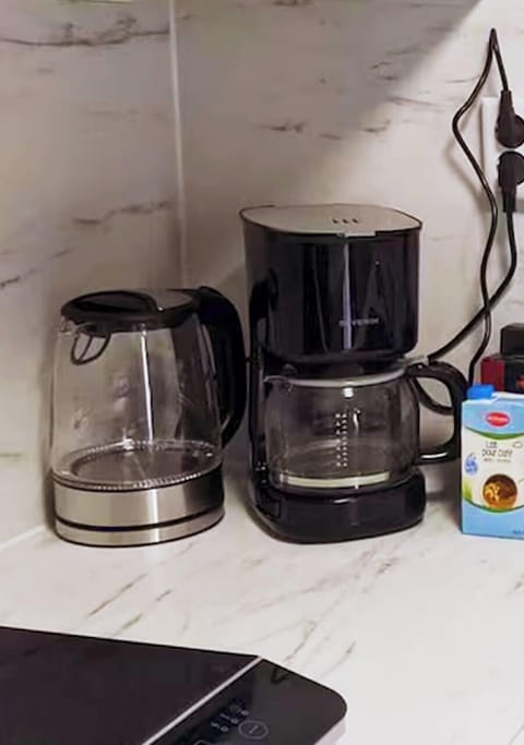 The kitchen is equipped with a modern electric kettle and a drip coffee maker, perfect for starting your day with a hot drink. Coffee creamer is also provided.