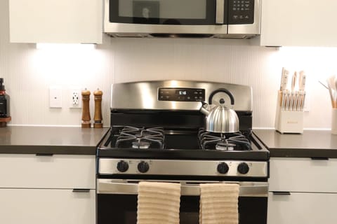 Experience extended comfort with a fully equipped kitchen featuring a coffee machine, stovetop, and microwave—everything you need for a seamless long-term stay