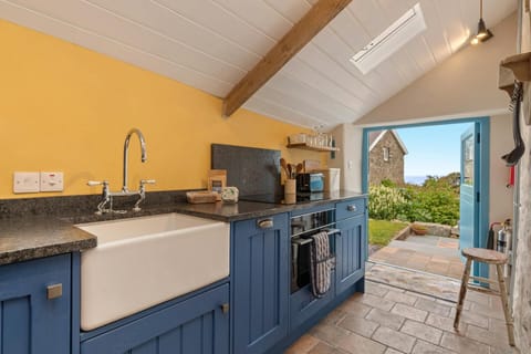Blue painted base units with Belfast sink. Double doors leading to garden