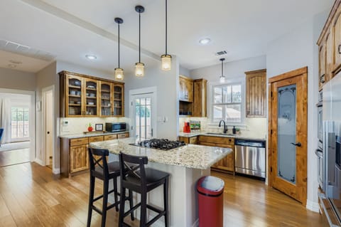 Gourmet kitchen with island seating and stainless-steel appliances.