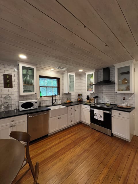 Kitchen features warm original hardwoods, window, and ceilings. All else is new!