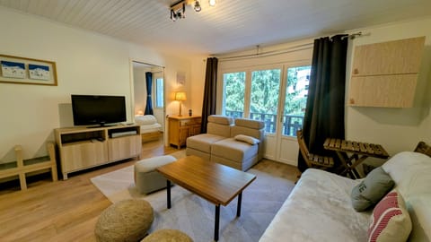 Bright and cozy living room with natural light, smart TV, and direct access to the balcony.