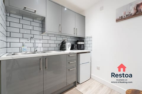 Sleek kitchen corner with fridge, kettle and cutlery