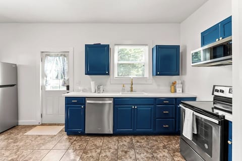 Bright, functional kitchen with bold blue cabinets, modern appliances, and plenty of counter space, perfect for cooking together and enjoying effortless meals during your stay.