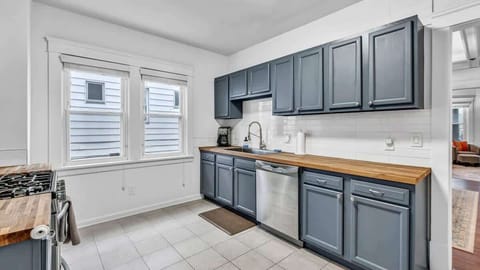 Bright and spacious kitchen featuring modern blue cabinetry, butcher-block counters, and stainless appliances — perfect for preparing home-cooked meals in style.