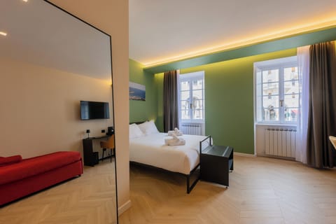 Deluxe Triple Room, Balcony, City View | Desk, blackout drapes, soundproofing, iron/ironing board