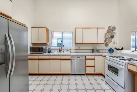 Fully stocked kitchen with drip coffee maker and functional white stove/oven.