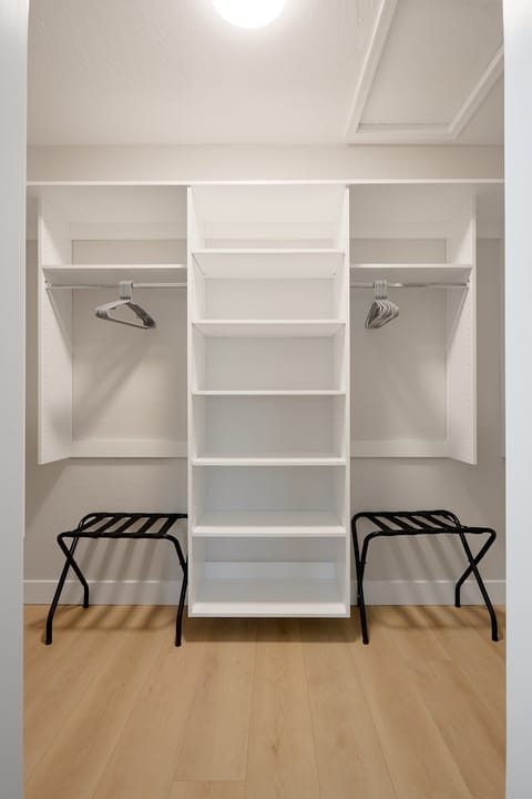 Inviting primary bedroom with a King bed, cozy seating, walk-in closet, en-suite bathroom, and private balcony, creating a serene retreat with warm, natural tones.