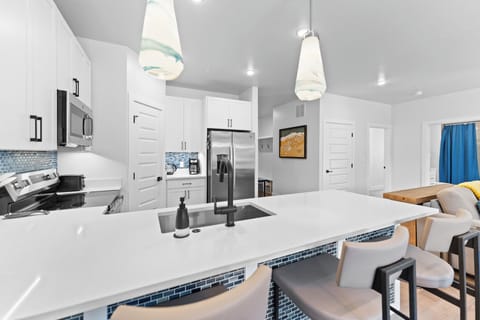 Full kitchen with stainless steel appliances and breakfast bar seating
