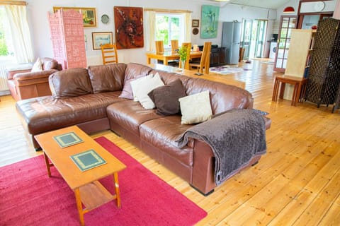 Living room with sofa set, floor rug and wooden coffee table.