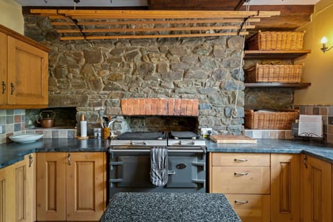 Everhot cooker, Stone feature wall with baskets on shelves to the side