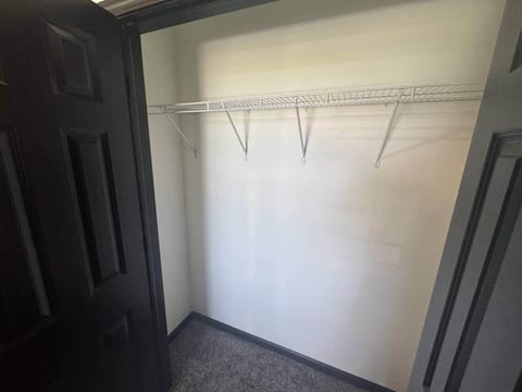 The spacious closet in bedroom 3 is shown with both doors open.