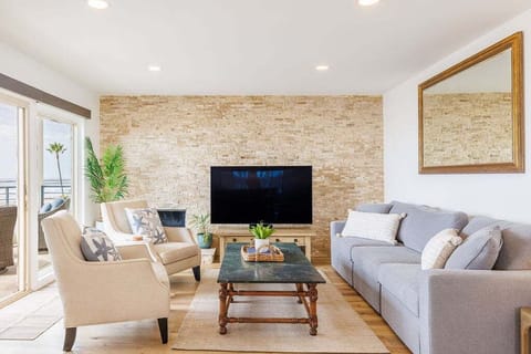 A bright and spacious living room featuring a large, comfortable sofa and two stylish armchairs