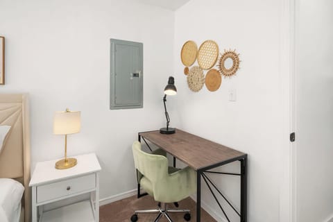 A perfect workspace for productivity, complemented by charming wall decor and a comfy chair.