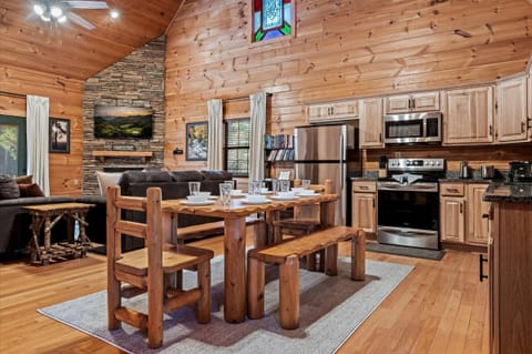 Enjoy a spacious kitchen with modern appliances, plenty of counter space, and a beautiful wooden dining table ideal for gathering.