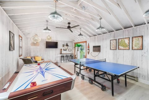 Game room with air hockey and ping pong, Boho lounge and TV.