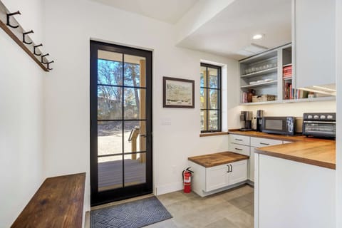 A bright, functional entry nook combines style and purpose with a built-in bench, sleek cabinetry, and modern appliances. This thoughtful space makes coming and going effortless during your Broadmoor stay.