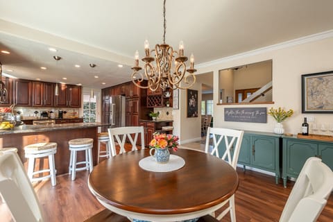 An inviting eat-in kitchen setup with a round table for four sits just off the living room, creating a relaxed spot for coffee, snacks, or casual meals. The nearby kitchen bar adds seating for four more.