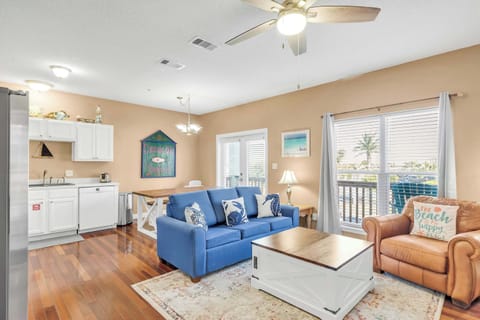 Living Room w/ Sofa Bed, Balcony Entrance & Kitchen