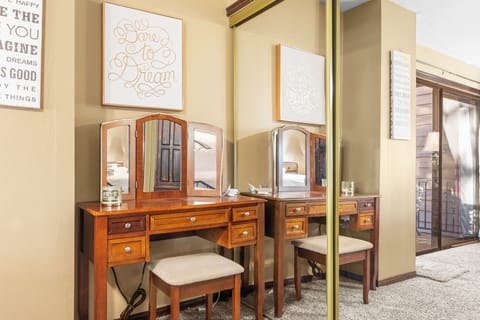 Dressing area with a vintage vanity and mirror in the primary bedroom.
