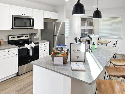 Your modern kitchen awaits with sleek marble countertops, stainless steel appliances, and a breakfast bar perfect for morning coffee. Natural light streams through the windows as you cook in this beautifully appointed space.