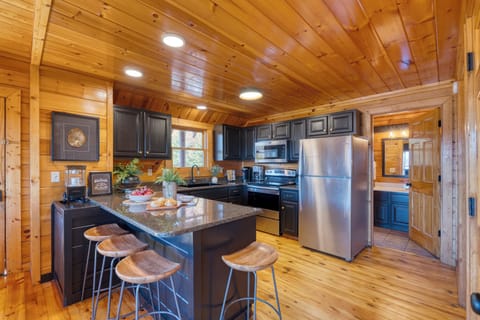 Fully equipped kitchen with granite counters, stainless steel appliances, and bar seating for easy vacation cooking.
