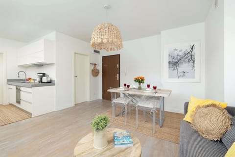 An open-plan living area combining kitchen, dining, and lounge spaces in neutral tones.