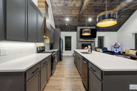 Open kitchen with modern finishes overlooking the cozy fireplace and living area.