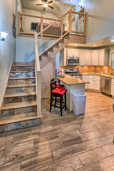 Kitchen island & stairs to loft. A child gate is at the top of the stairs.