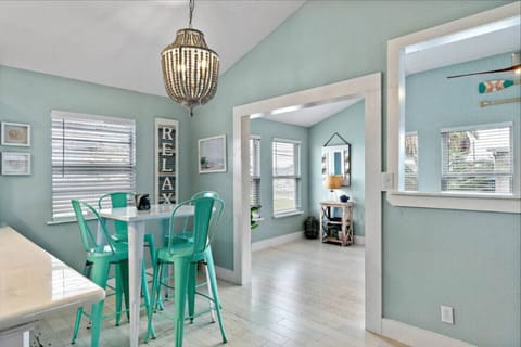 A breakfast nook has teal barstools and lots of natural light