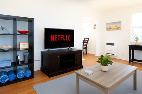 The spacious living room features a 55” Smart TV and a full-size futon, perfect for families or extra guests. A dedicated work desk provides a convenient space for remote work or planning your next adventure.