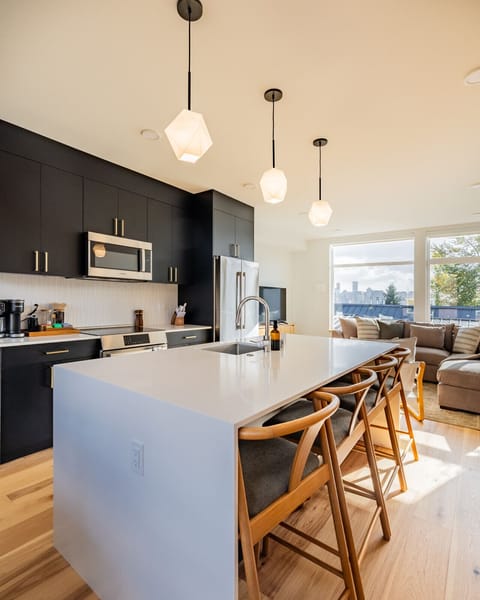 Spacious kitchen with a large island that opens seamlessly into the modern living room - perfect for cooking and gathering.