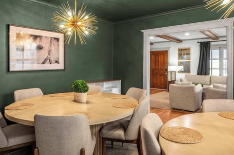 Gorgeous dining area that features a unique gold accents, soft textures, and a serene layout designed for comfortable meals and effortless gatherings with access to the living room.