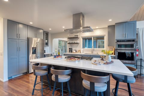 Modern chef’s kitchen with a spacious island, sleek appliances, and seating for the whole group to gather.