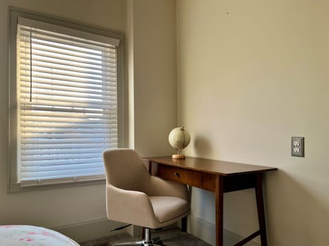 Bedroom 1 features a small desk and comfortable office chair.