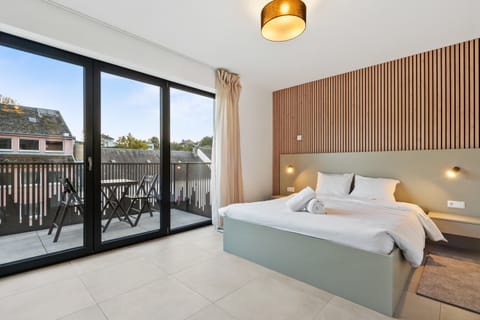 Inviting Living and Sleeping Space – Unwind in a cozy area featuring a queen-sized bed and a sophisticated wooden accent wall.