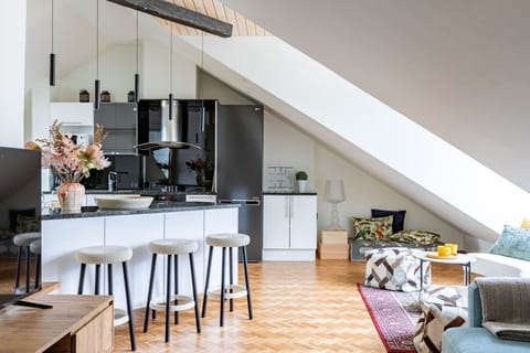 Modern kitchen featuring a large island with stylish bar stools — a welcoming space for relaxed breakfasts or evening drinks.