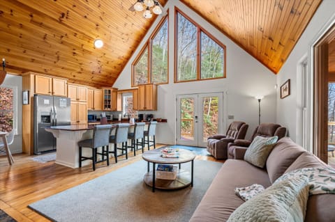 Open-concept living: kitchen bar, seating, and vaulted ceiling.