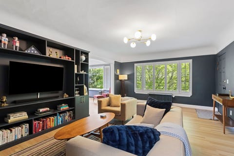Main living space65" OLED tv with 4K AppleTV, original 1926 flooring, and beautiful light from banks of windows!