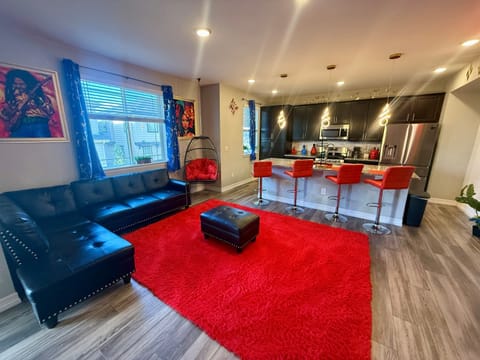 Inviting open concept living area with comfy seating, & a kitchen island with bar stools, great for relaxing, watching TV, & staying connected while you cook & hang out together.