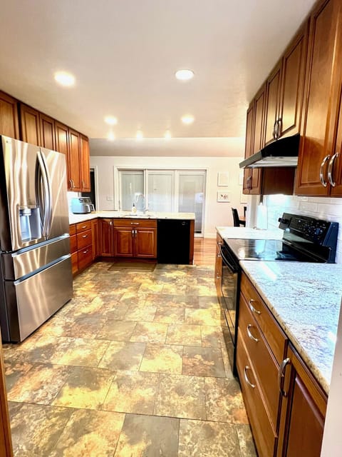 Open kitchen, electric range, stainless refrigerator
