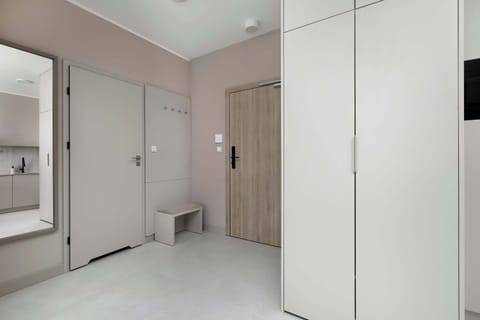 Entrance hallway with spacious built-in wardrobes and bright lighting.