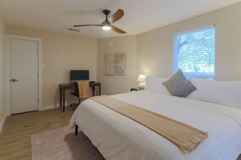 Guest Bedroom (end of the house): Leesa Sapira Chill Hybrid king bed with work-from-home setup, including desk, monitor, mouse, and docking station. Closet with portable fan, books, board games, luggage rack, sleeping machine, ear plugs, and extra be