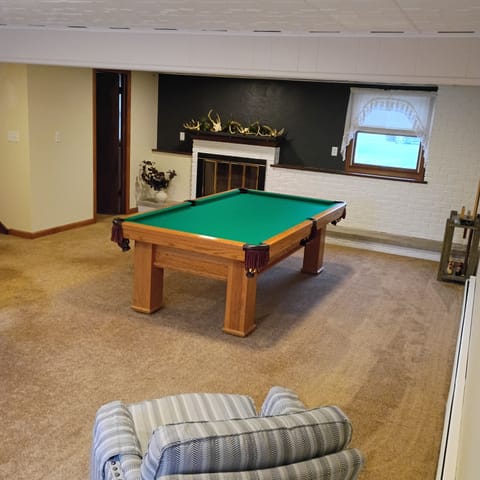 Level up your stay in the cozy game room. Pool table, fireplace, swivel chair.