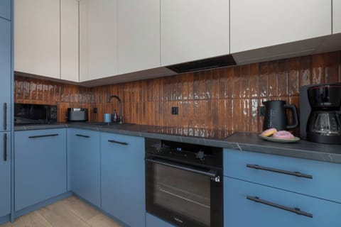 The kitchen space, with its practical countertop and cohesive colors, encourages preparing home-style dishes in a setting that blends function with style.