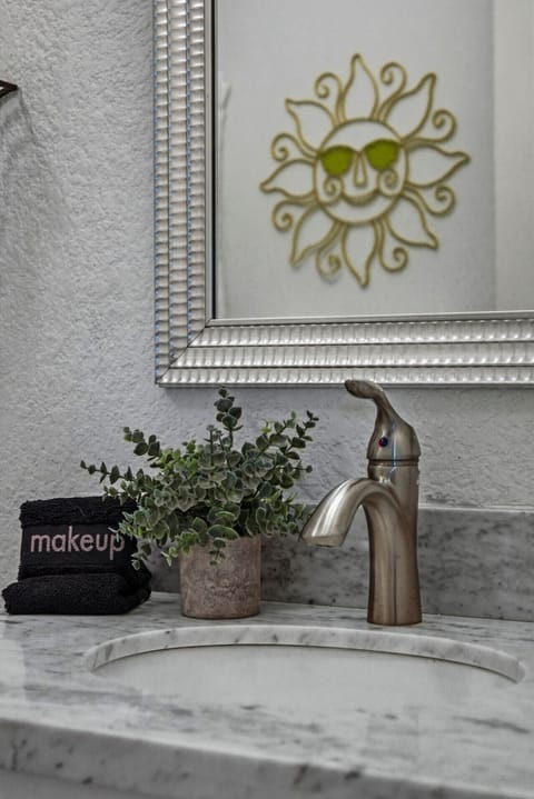 Start your day with a smile—marble vanity, cheerful sun mirror, and plush towels bring a little extra joy to your morning routine.